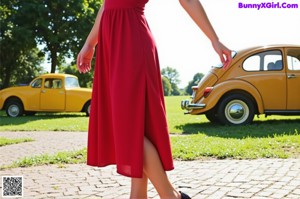 A woman in a red dress posing by a window.