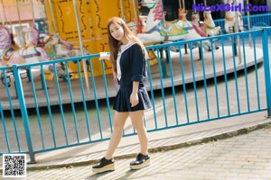A woman in a school uniform posing for a picture.