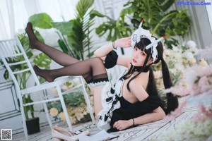 A woman dressed as a maid holding a knife.