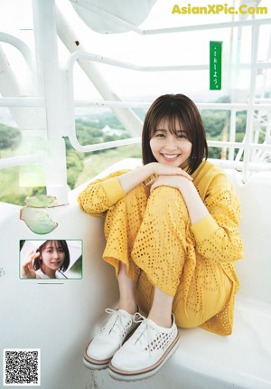 A woman in a bathtub smiling at the camera.