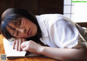 A woman laying on a bed reading a book.