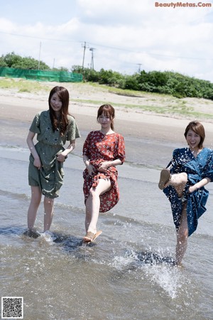 A group of three young women in lingersuits standing next to each other.
