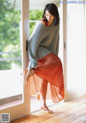 A woman sitting on a rug in a room.