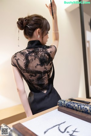 A woman in a black lingerie laying on a bed.