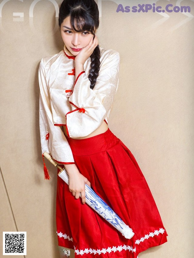 A woman in a red and white dress holding a sword.