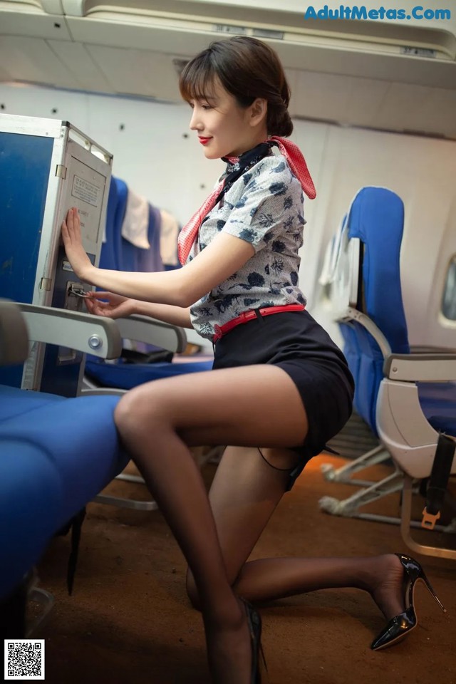 A woman in a skirt and stockings is sitting on an airplane.