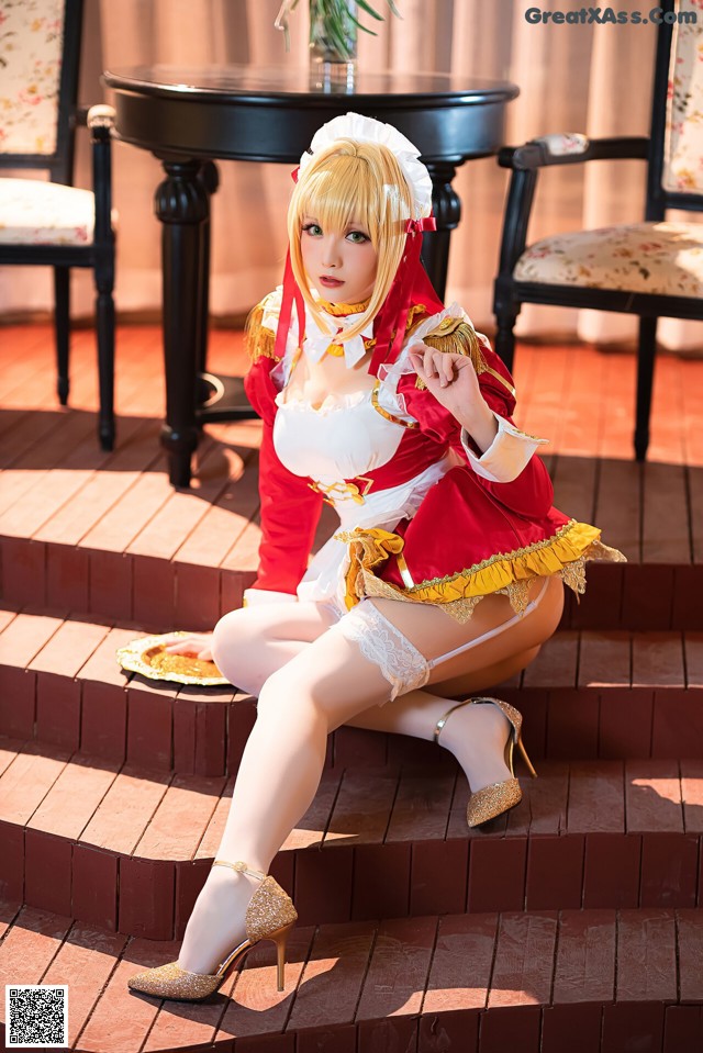 A woman in a red and white dress sitting on some steps.