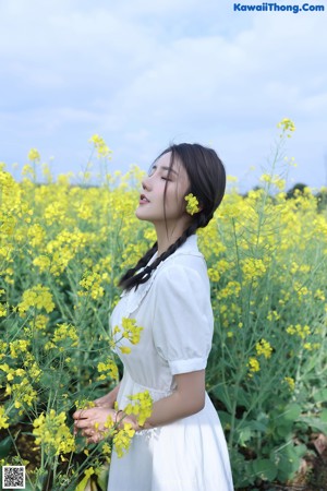 A woman in a field of yellow flowers.