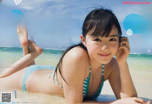 A woman in a pink and white bikini sitting by a pool.