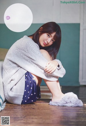 A woman laying on top of a couch next to a pillow.