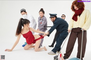 A woman in a red dress is being held by a police officer.