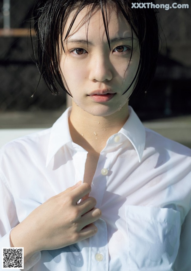 A woman in a white shirt is posing for a picture.