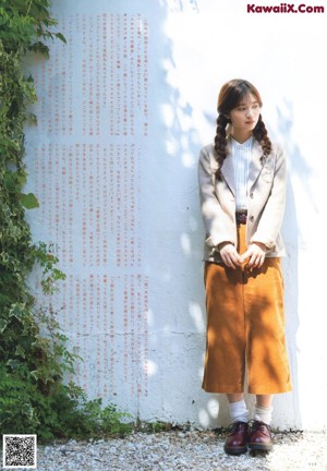 A woman in a white dress walking through a field.