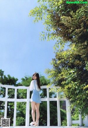 A woman in a white dress holding a bouquet of flowers.