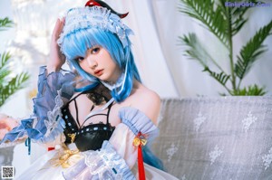 A woman with blue hair wearing a maid outfit.