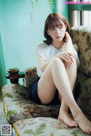A woman in a white blouse and blue skirt posing for a picture.