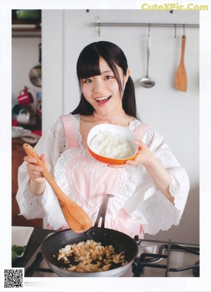 A woman standing on top of a red stool in a kitchen.