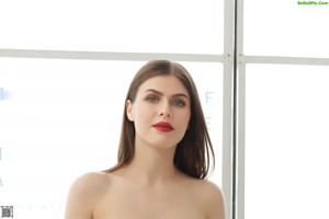 A nude woman sitting on top of a brown chair.