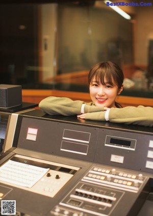 A woman wearing headphones making a peace sign with her hands.