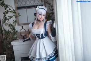 A woman in a blue and white dress is posing for a picture.