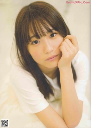 A woman in a white dress is posing for a magazine.