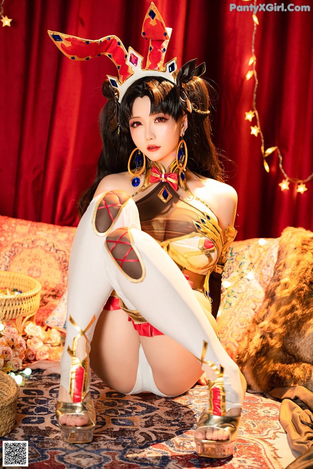 A woman in a costume sitting on a couch.