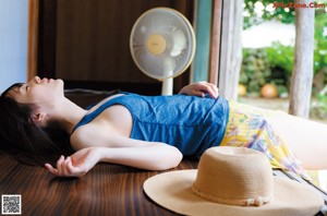 A woman in a yellow bikini laying on a bed.